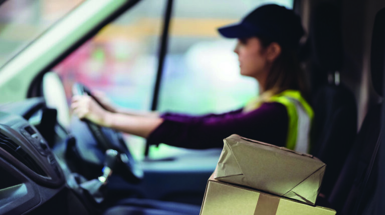 How can you prepare for the latest trends affecting final-mile logistics? Female delivery driver in van with two parcels on front seat