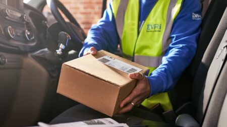 Evri announces peak season delivery record and larger Tyneside facility An Evri employee handles a parcel in the front cabin of a delivery vehicle, while wearing a yellow high-vis vest