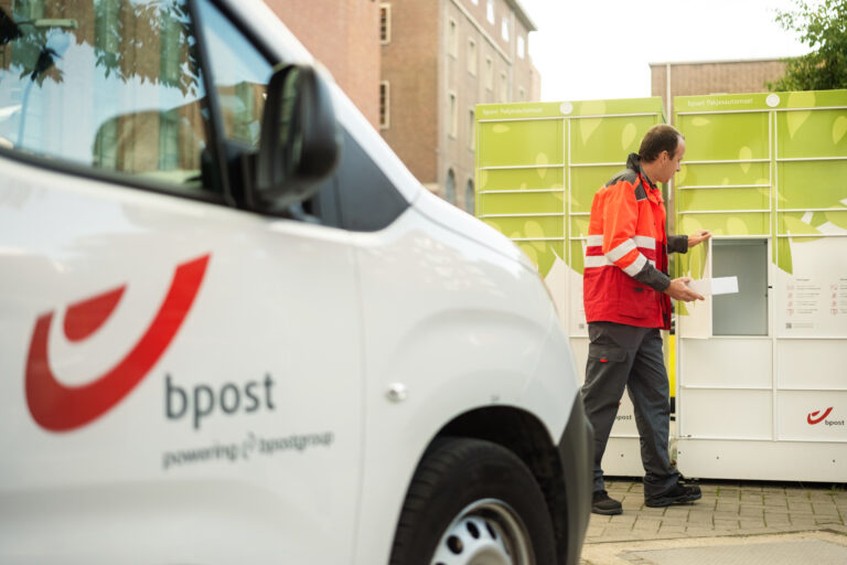 bpost launches carbon calculator for sustainable logistics in Belgium bpost delivery person placing a parcel in a green parcel locker