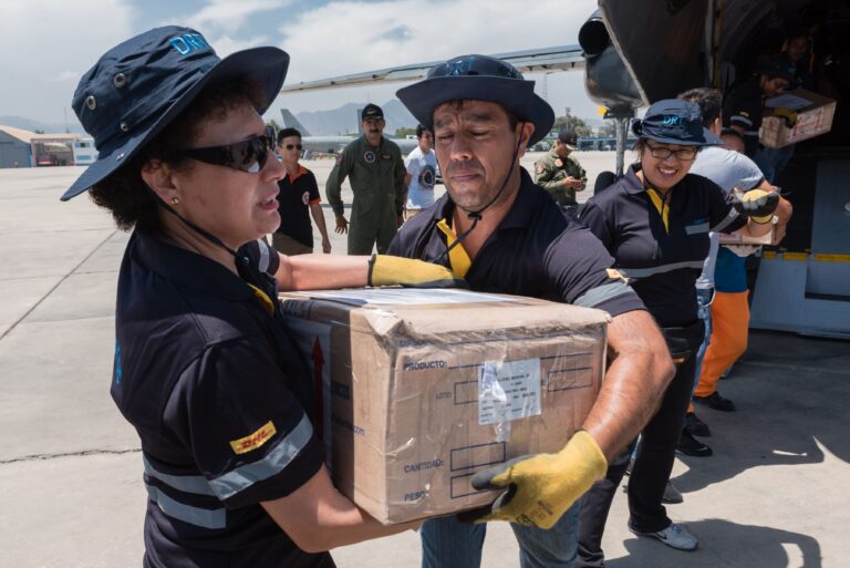 DHL Group achieves top marks for social commitment DHL employees taking aid boxes from a cargo plane