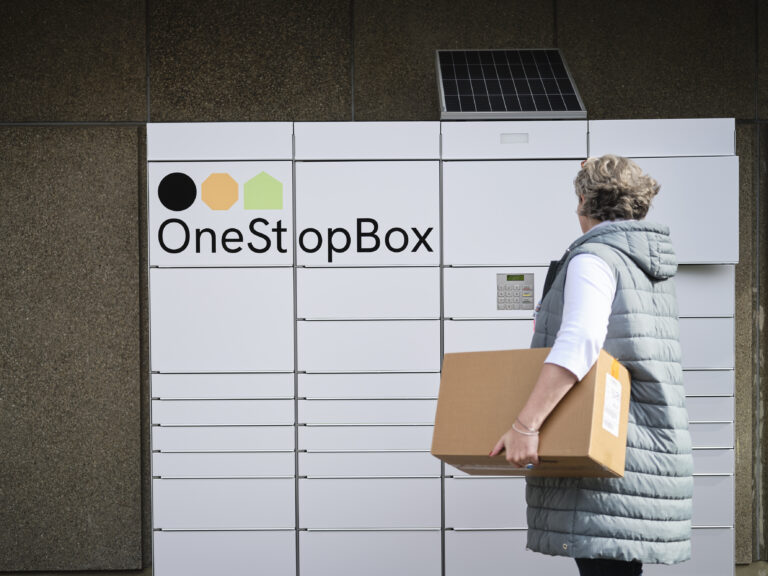 Agnostic parcel lockers launched by DHL Group Female customer using the OneStopBox parcel locker to send a parcel