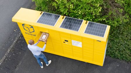 Pickup debuts France’s first solar-powered parcel lockers Man posting a parcel into a yellow Pickup locker with solar panels on the top.