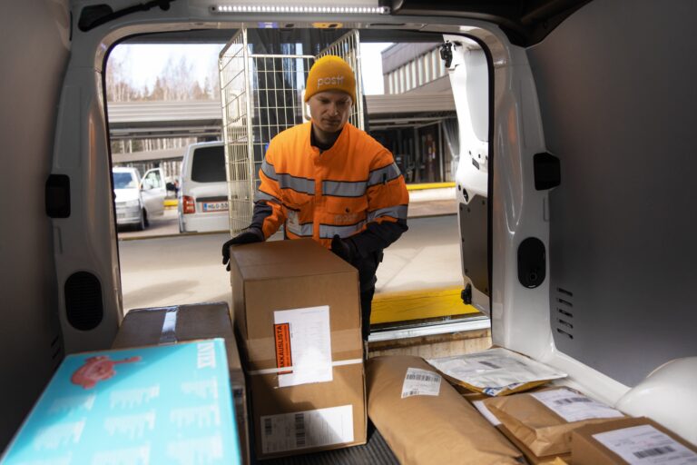 Posti to lose up to 295 staff with planned e-commerce and delivery services reform Posti worker placing parcels in a van for delivery