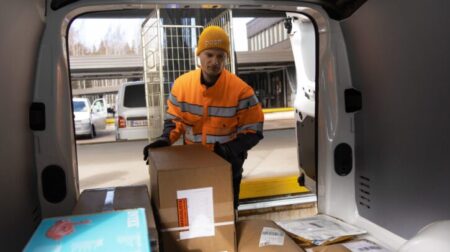 Posti worker placing parcels in a van for delivery