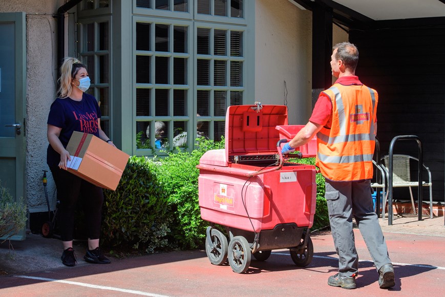 Royal Mail worker collecting a parcel at a care home