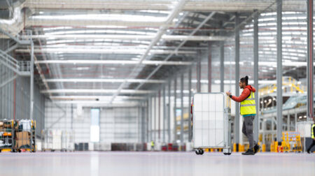 Royal Mail worker pushing trolley in Midlands Superb, Daventry, UK
