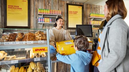Woman and boy collecting parcel at DHL shop.