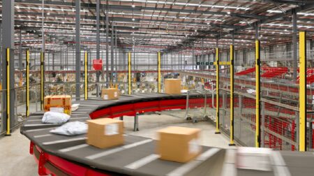 Australia Post’s Post26 strategy starts to pay off with improved financial results Australia Post parcel facility with parcels on sorting conveyor.