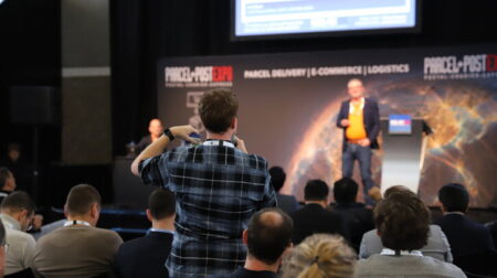 Parcel+Post Expo Innovation Forum highlights – editor’s picks Man in audience standing to ask question during conference session.