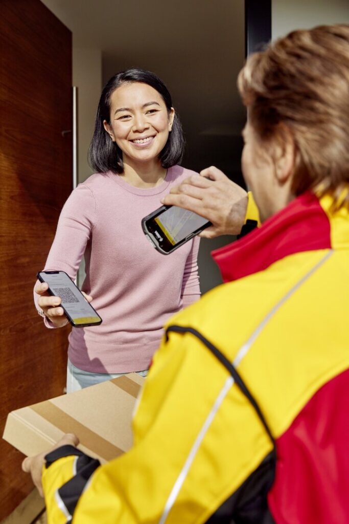 DHL worker scanning customer's QR code for parcel return on the doorstep