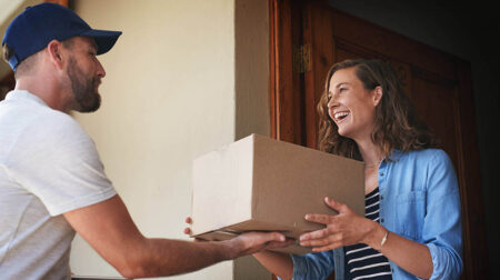 Happy woman, delivery man and package box at door for order, parcel or cargo of customer in transport service. Female person receiving shipment from male courier, supply chain or deliver at the house