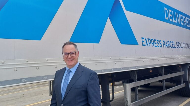 Ian Truesdale stands in front of a DX Group truck.