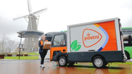 Third of PostNL’s last-mile deliveries now emission free A PostNL delivery truck parked in front of a windmill