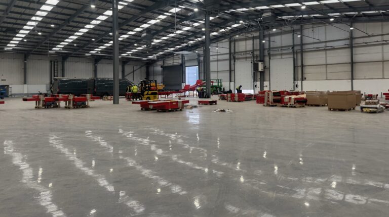 DHL eCommerce opens new UK facility The inside of the new DHl eCommerce facility in Birmingham, UK, with an mostly-empty floorspace and sorting equipment being installed