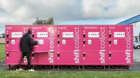 A block of pink shift Collect parcel lockers in a parking lot location outside a building