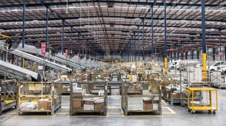 Australia Post announces A$18.8m profit despite substantial letter losses A postal logistics warehouse with cages of post for delivery