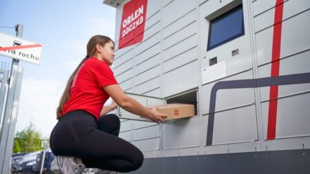 Poczta Polska acquires minority stake in Orlen Paczka A Poczta Polska team member delivers a package to a parcel locker