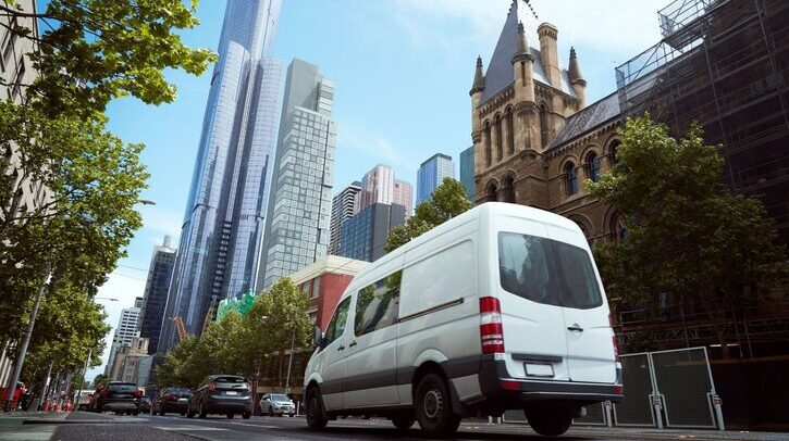 White delivery van in busy urban setting.