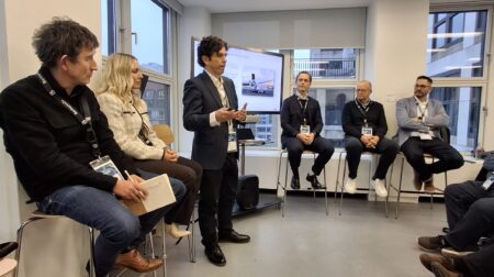 EXCLUSIVE INTERVIEW: Carlos Setien, innovation manager at International Post Corporation Carlos Setien, innovation manager at International Post Corporation, discusses postal regulation in a workshop in a small room in front of a projector screen.