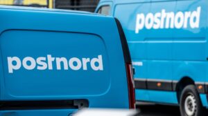 Blue Postnord delivery vans parked by a warehouse in Gothenburg.