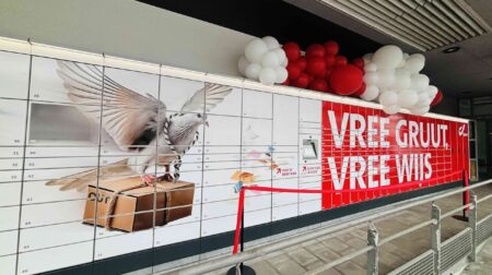 Bpost installs largest parcel locker facility in Belgium The Bpost parcel locker facility in Ghent in Belgium, with banks of lockers. It is white with some red advertising on one end.