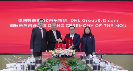DHL Group and JD.com partner to support German brands’ growth in China and Europe Tobias Meyer, CEO, DHL Group; Dongming Wu, CEO, DHL Express China; Eric Zheng, head of global service, Jingdong Logistics; Sandy Xu, CEO, JD.com. shake hands at the singing of an MOU in front of red JD.com branding.