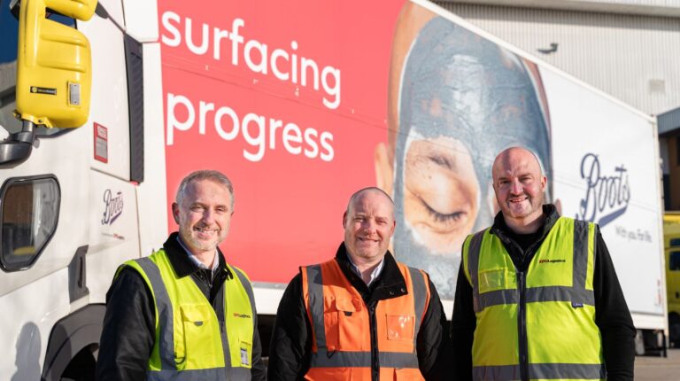 Boots and XPO Logistics representatives stand in front of a Boots-branded delivery truck.