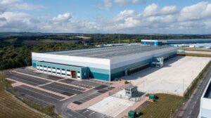 Aerial view of Evri's new £4m Barnsley fulfillment center. It has a grey roof and white and green sides. Green fields stretch out into the distance.