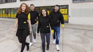 Male and female staff wearing the new black and yellow uniform.