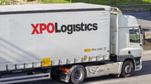 Xpo logistics branded truck trailer driving on a highway, symbolizing global transportation