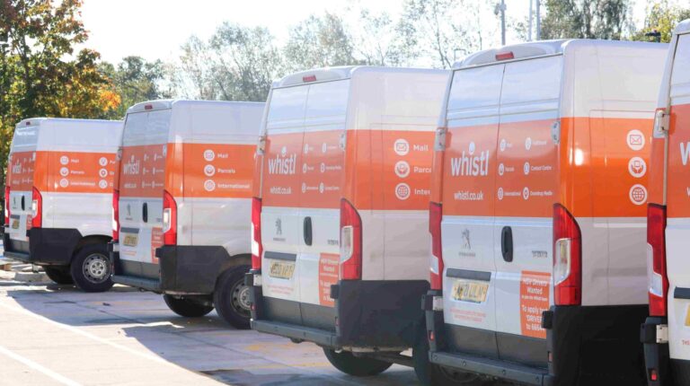 A line of Whistly delivery vans parked in a row.