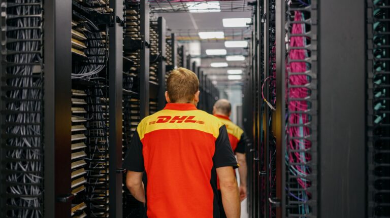 DHL expands data center logistics capabilities across Asia-Pacific Two DHL colleagues walking down a corridor of server racks.