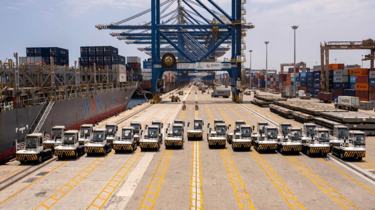 DP World deploys 35 electric terminal tractors at Jeddah port Electric terminal tractors parked in a curved line at DP World's Jeddah port.