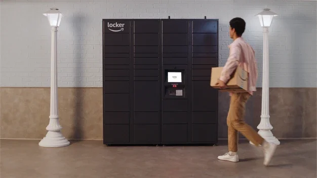 Amazon expands Locker network to more than 750 US college locations A man wearing a light brown shirt and darker brown trousers drops off a parcel at a bank of Amazon Lockers.