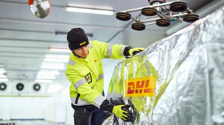 DHL to open healthcare logistics center at Changi Airport A young warehouse worker is checking pallets that have been covered for transport.